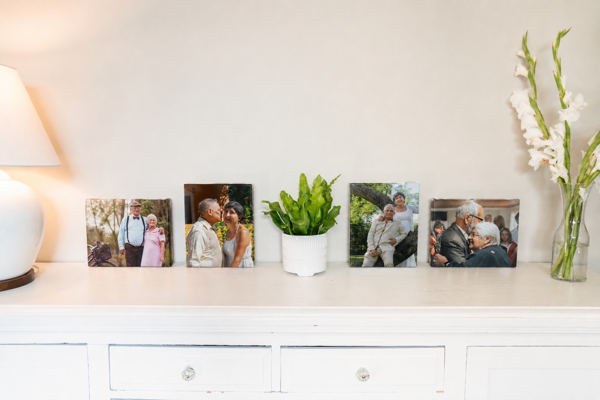 A row of small SimplePrints canvases of couples through the years, lined up along a white sideboard