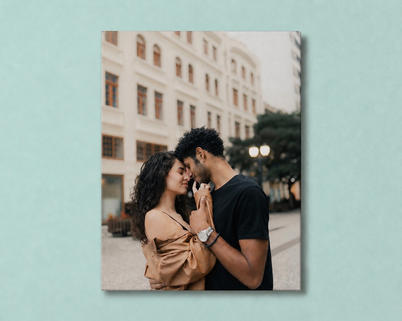 A couple forehead to forehead on a city street, printed as a SimplePrints canvas on a green wall