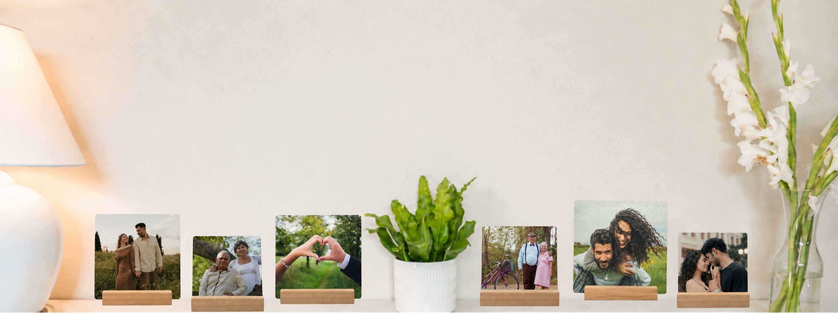 A row of SimplePrints desk prints of couples on their wooden stands, lined up along a shelf