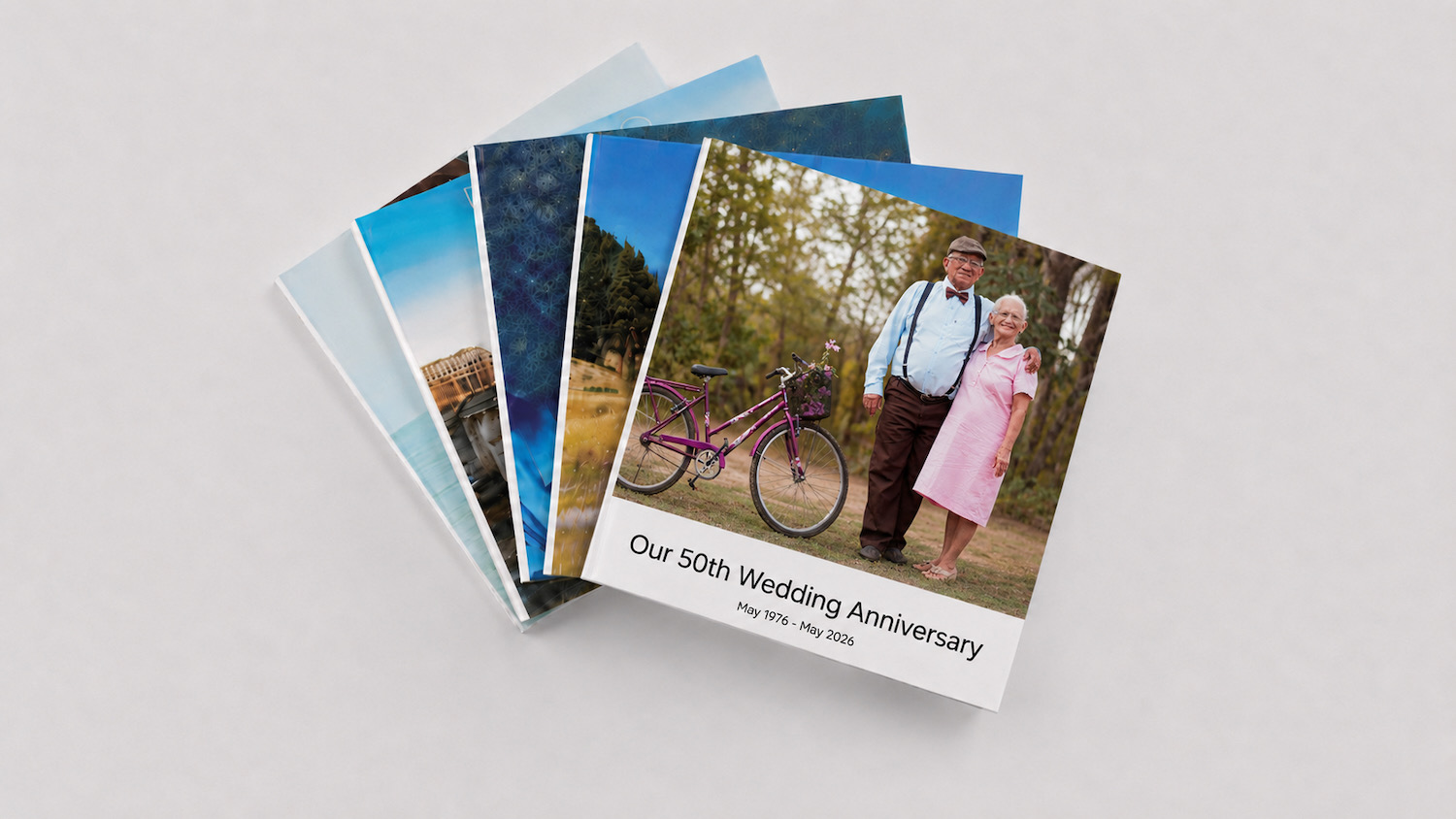 A fanned stack of SimplePrints photo books, the top one titled for a 50th wedding anniversary