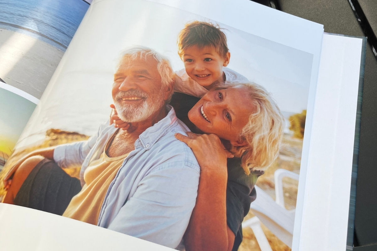 A photo book with a picture of a boy with his grandparents at the beach