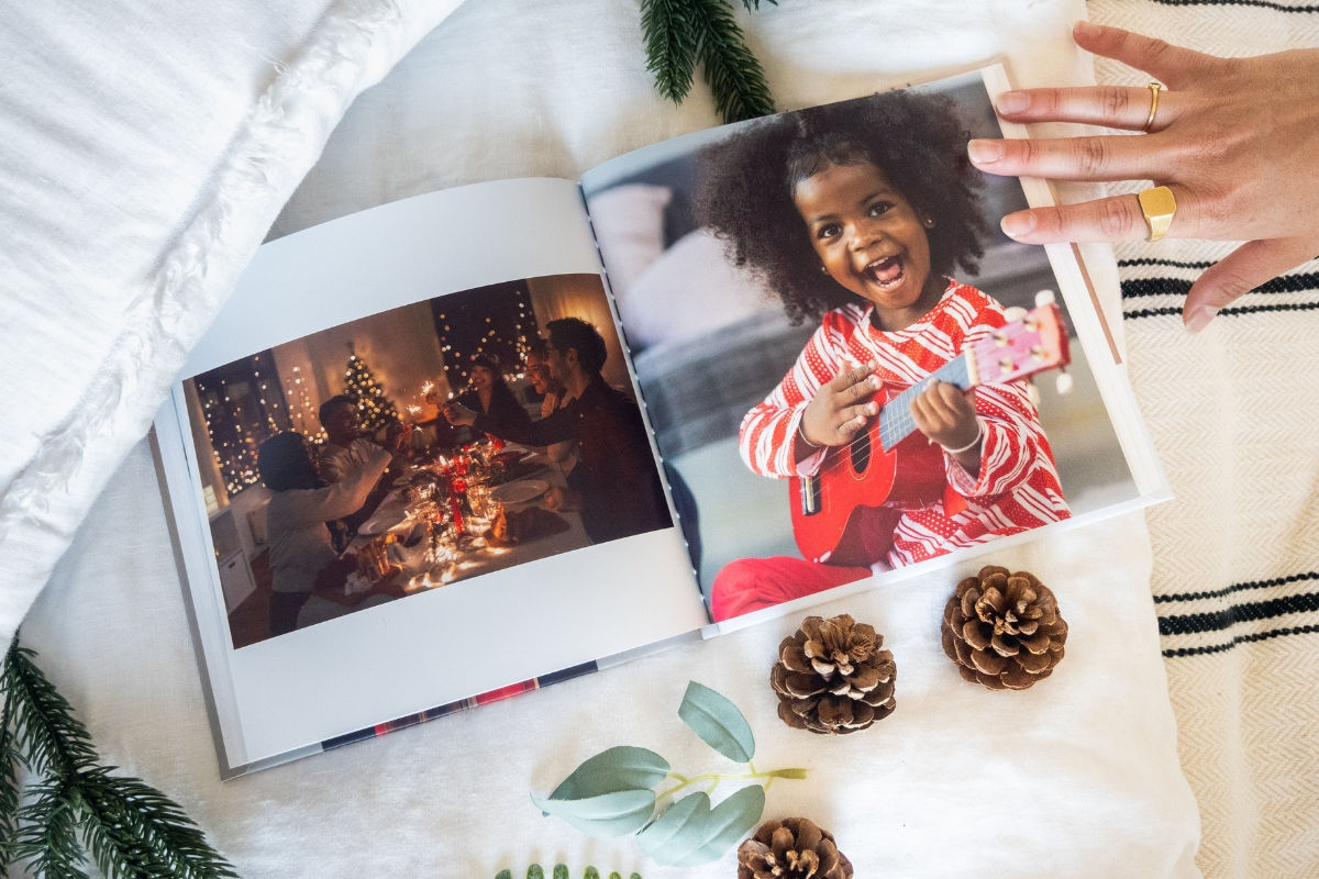 A photo book depicting a family eating dinner with a Christmas tree in the background