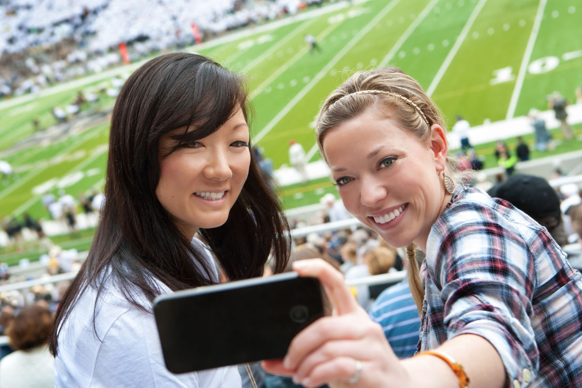 couple taking a selfie in a football game