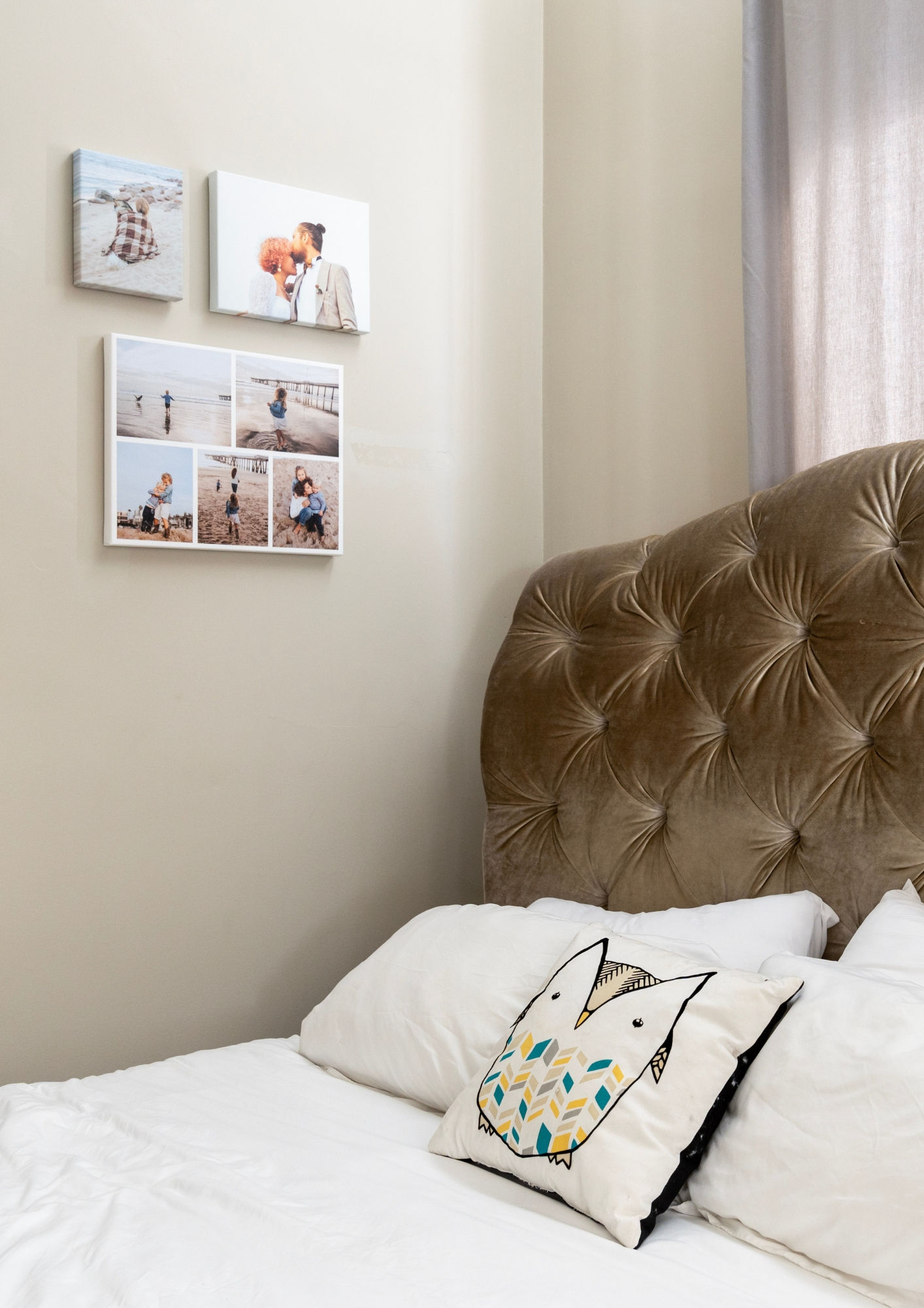A bedroom with a gallery wall of canvas prints showing images of a couple and their family.