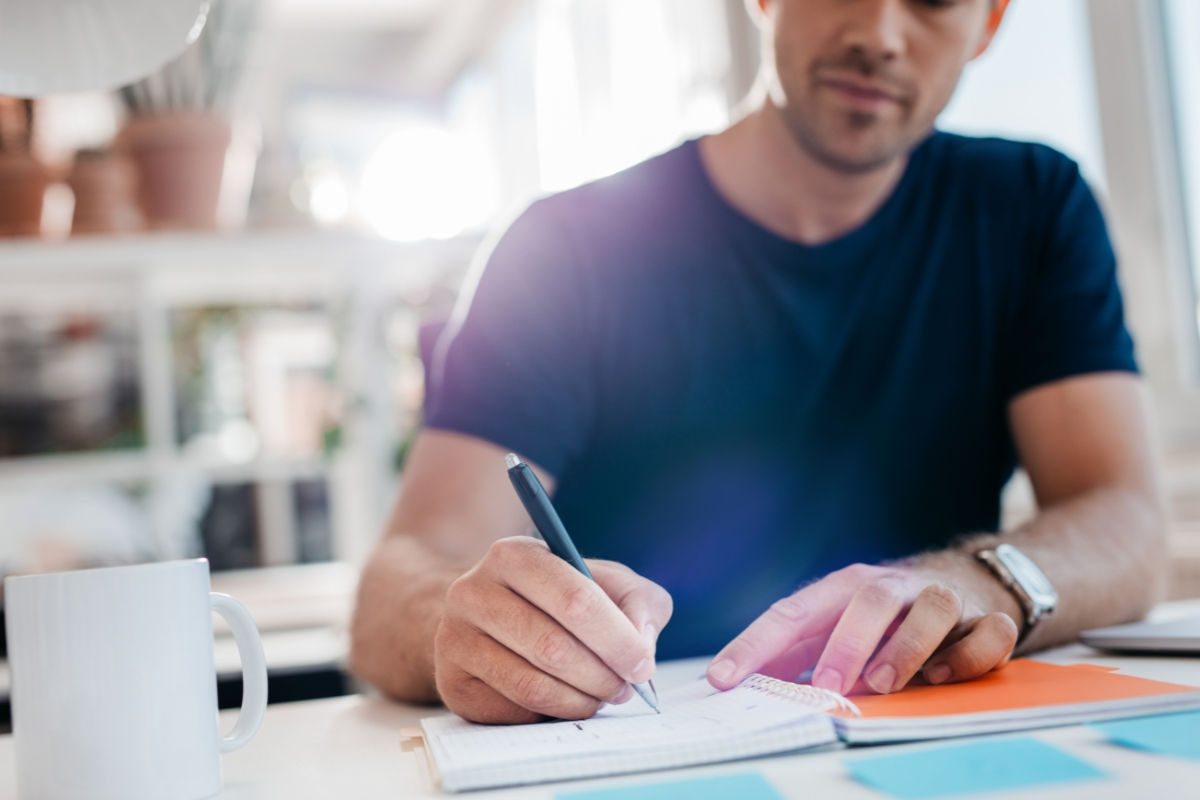 man writing a handwritten note