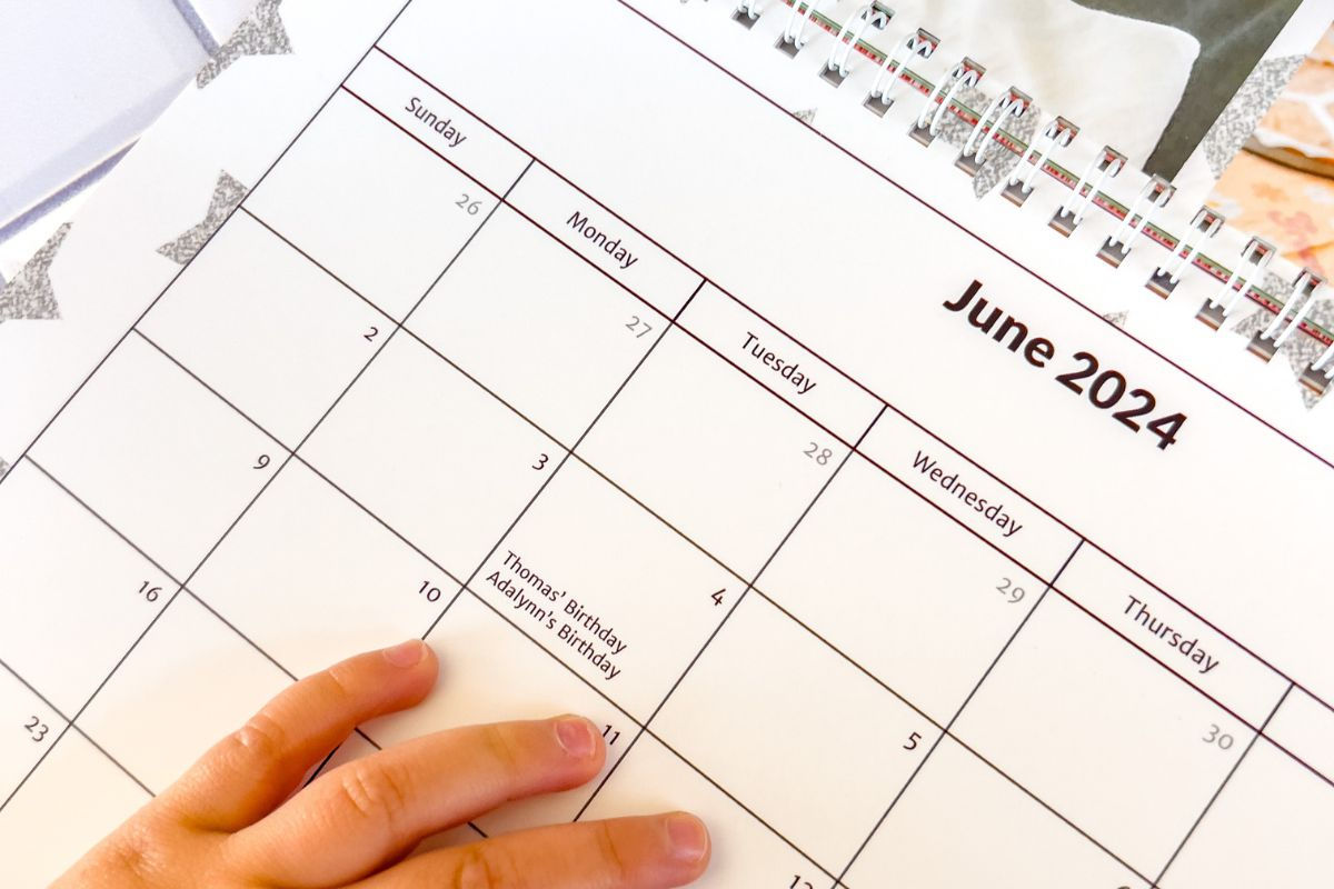 A child hand on a calendar showing custom birthday events added