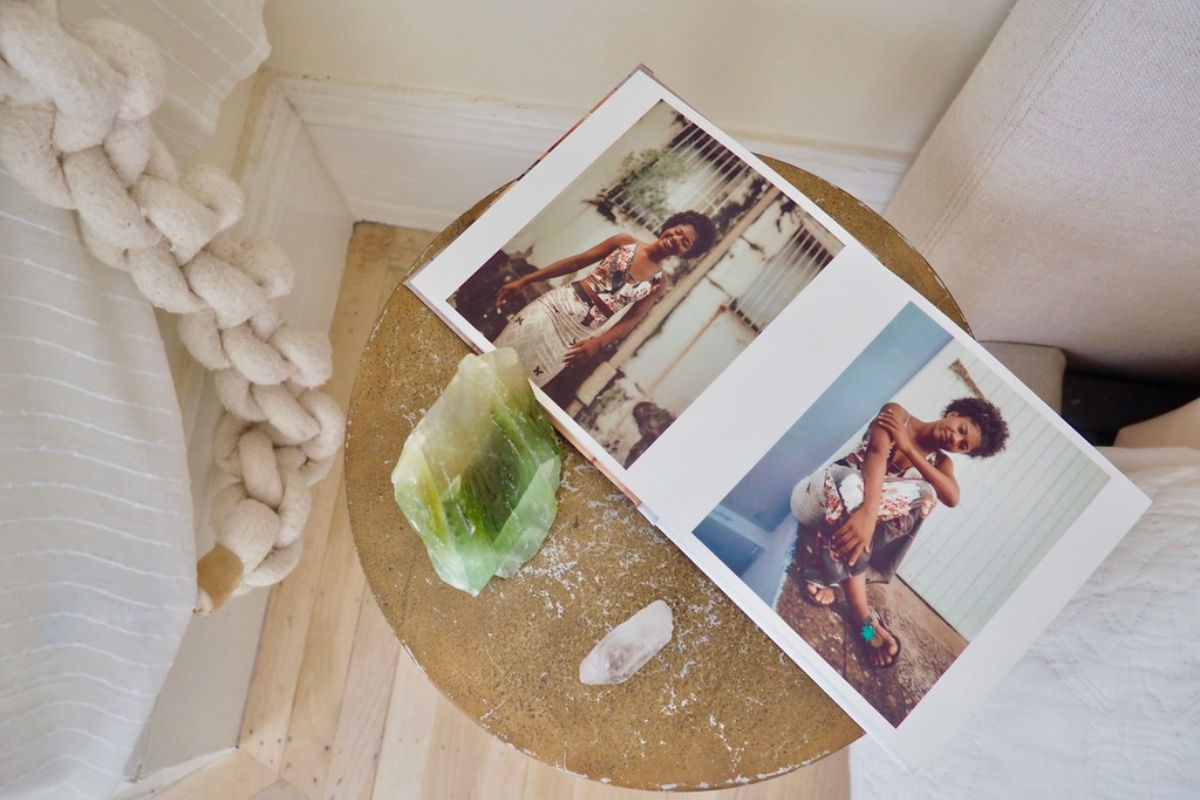 a photo book of a woman on a wellness retreat with crystals surrounding the photo book
