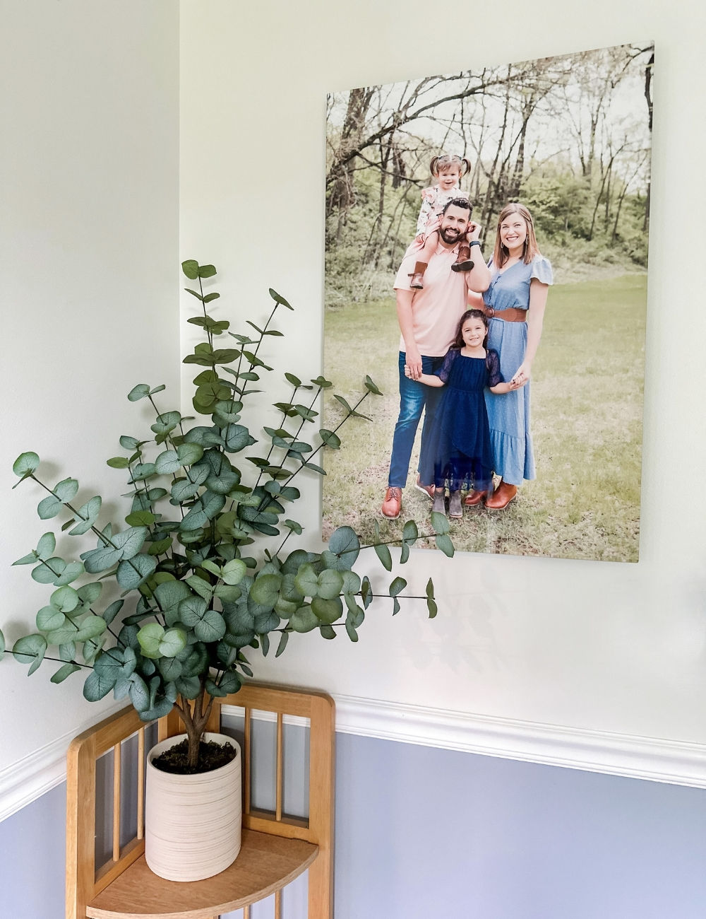 a metal print on the wall with a family in their Sunday finest with a woodsy background