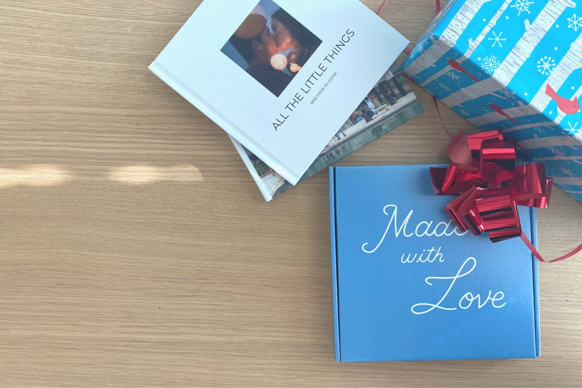 A stack of photo books next to a gift package from Simpleprints that says made with love