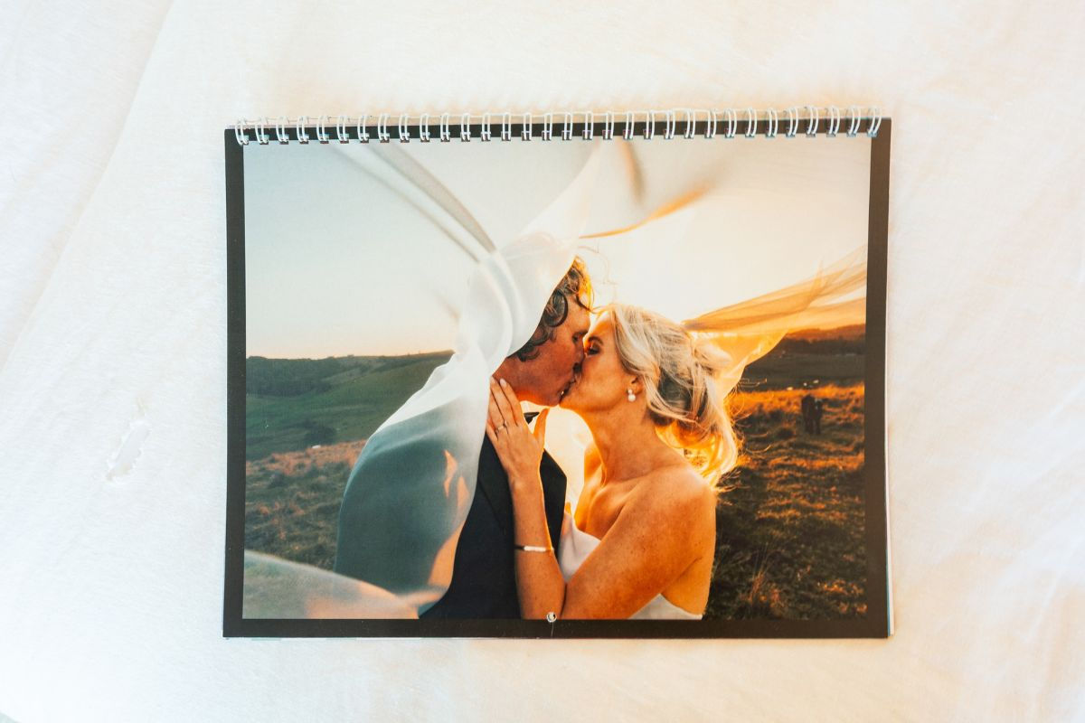 A photo featuring a bride and groom on the cover of a wall calendar with a black background