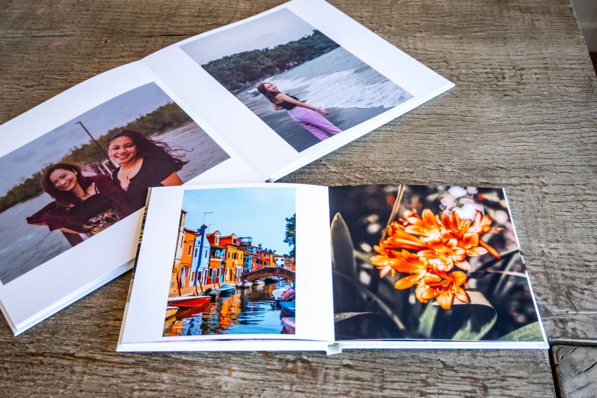 2 photos books with pictures of two girlfriends at a beach and a colorful city in the other.