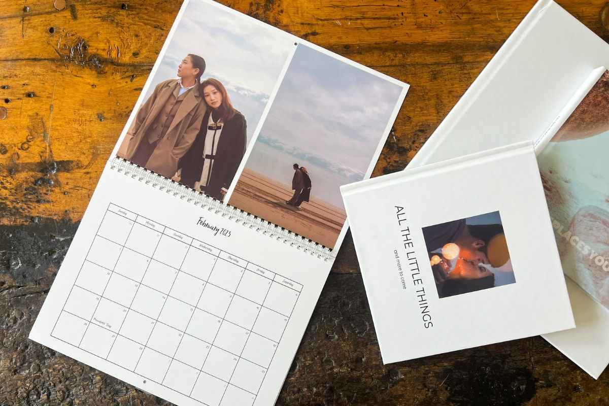 SimplePrints wall calendar and photo books on top of a wooden table