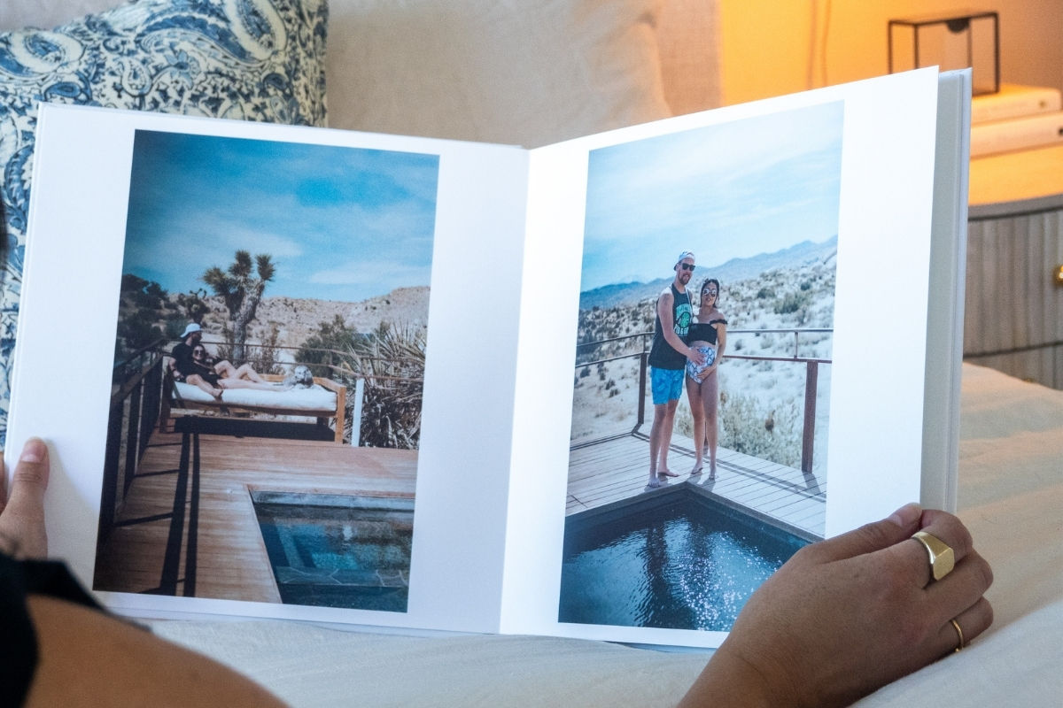 a photo book depicting parents to be posing by a scenic pool