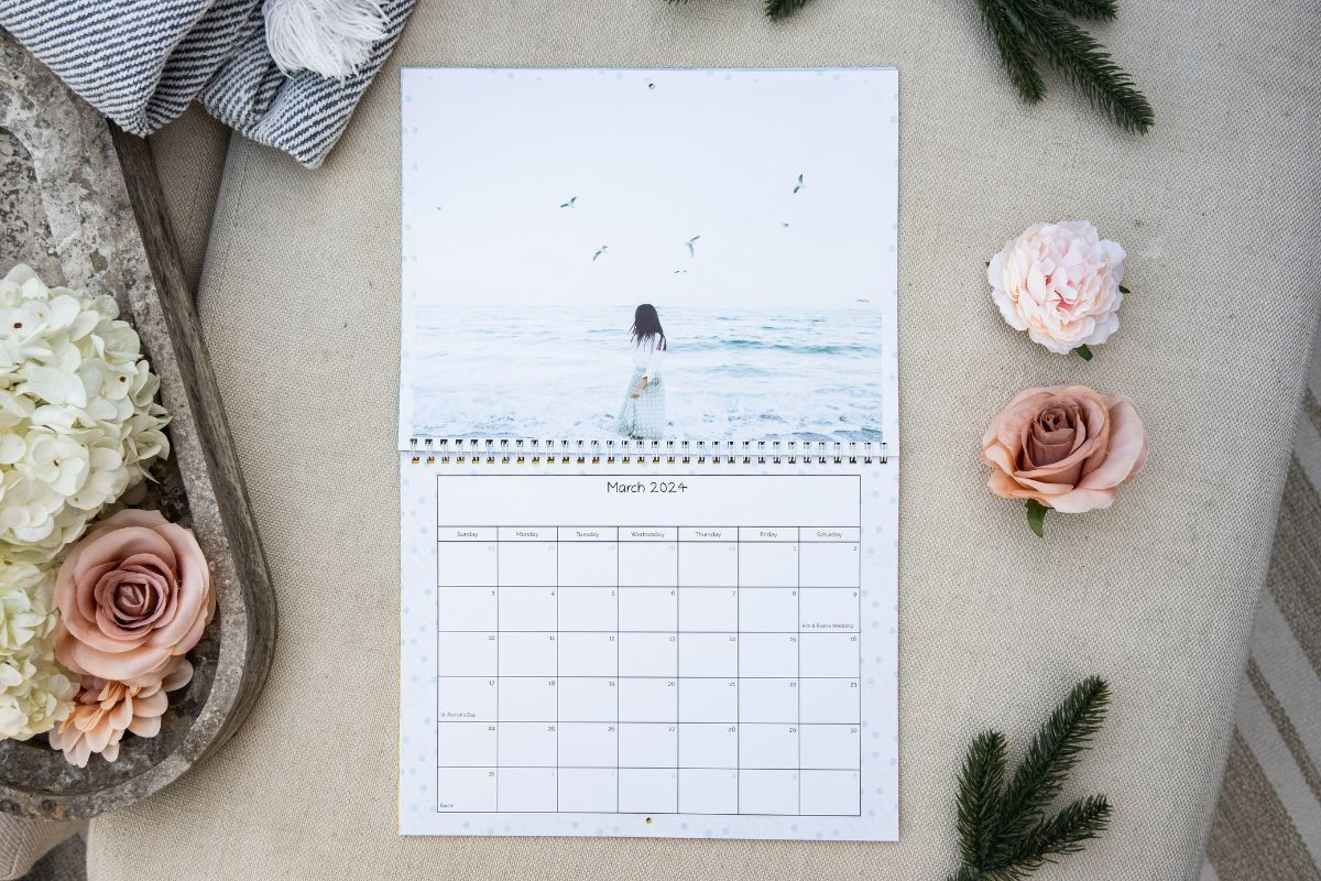 A calendar featuring a woman at the beach with a multi-colored blue dot background to match