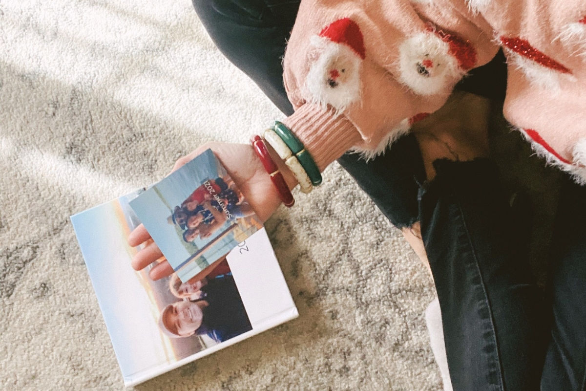 Person holding a SimplePrints Mini book on top of a SimplePrints photo book