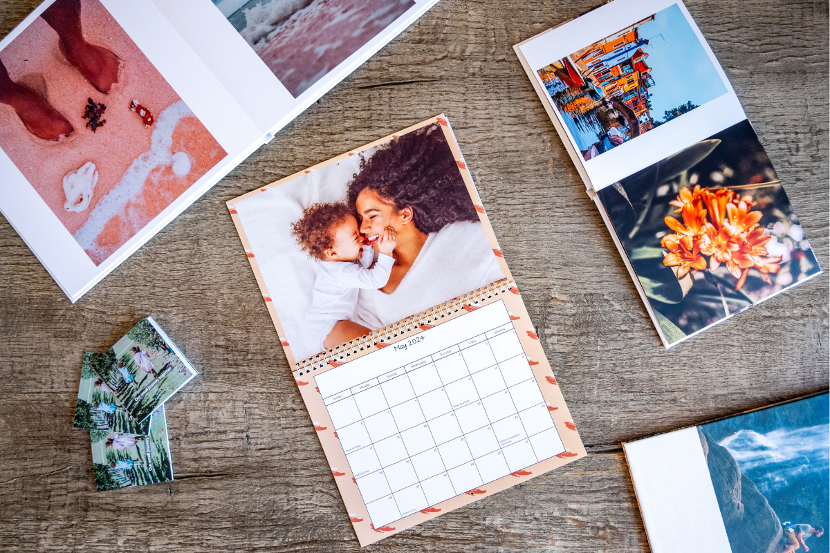 Wall calendar and two photo books on top of a wooden table