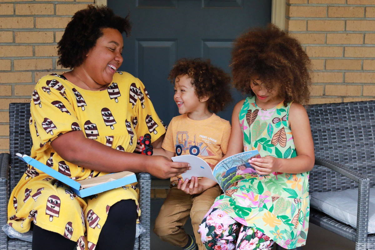 Mother showing her two kids a SimplePrints Softcover photo book