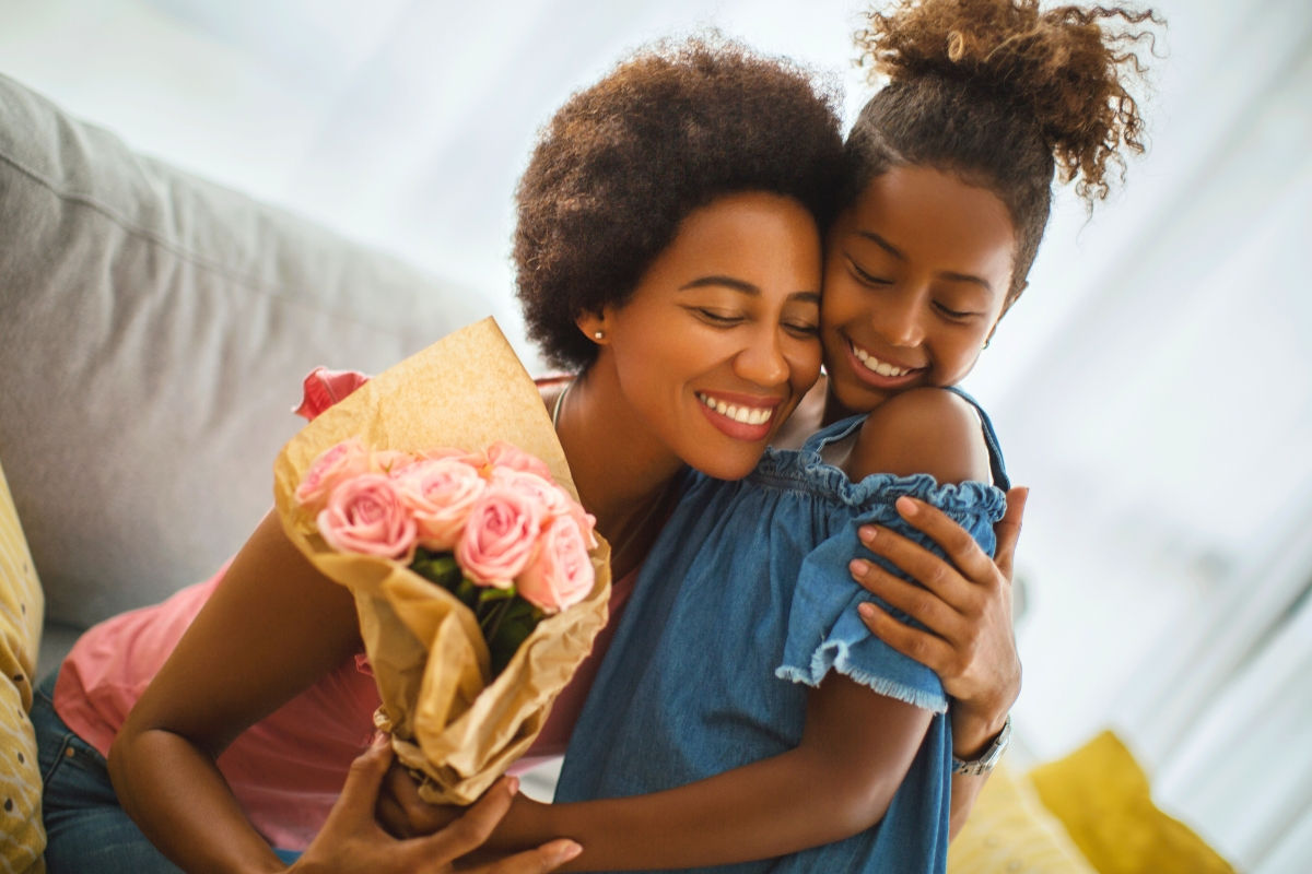 Daughter and mother embracing with flowers