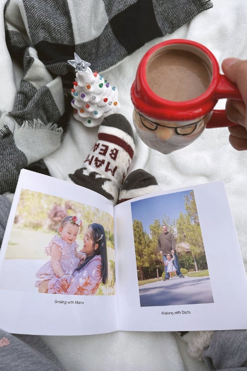 Person holding a SimplePrints Softcover Photo book and a cup of coffee