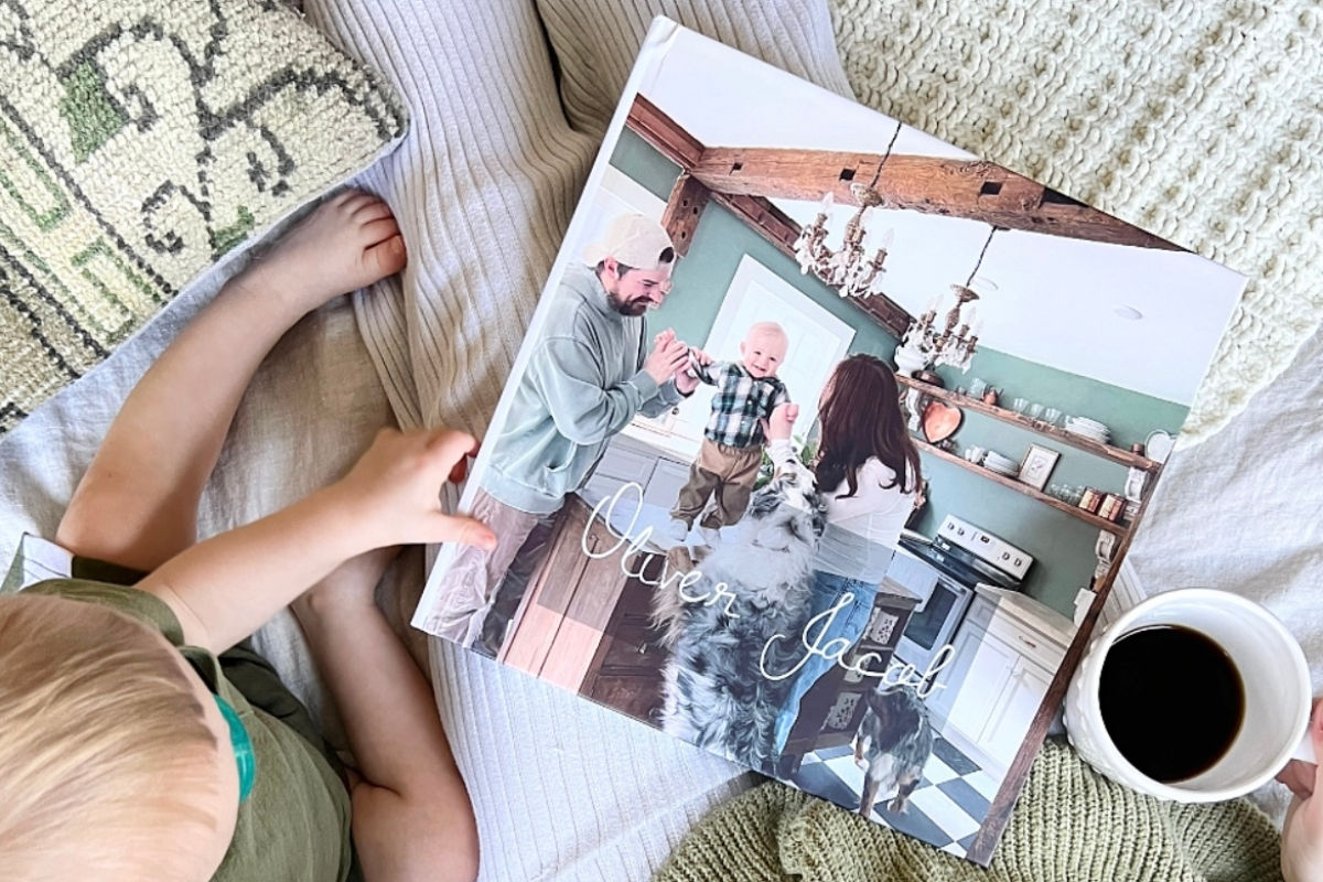 Baby holding a SimplePrints hardcover photo book of his baby pictures