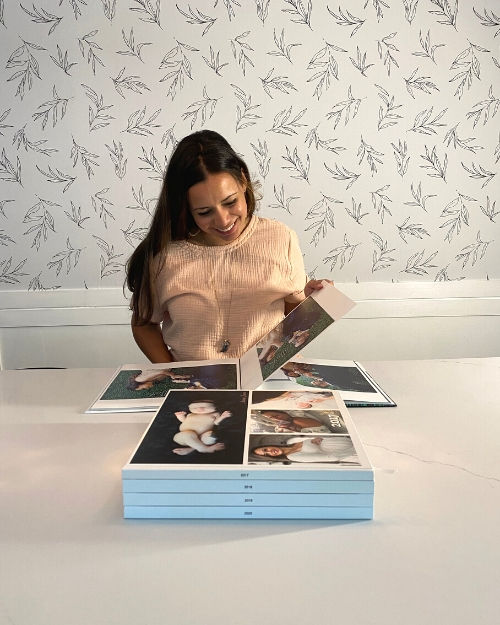 Woman with a stack of SimplePrints Photo books